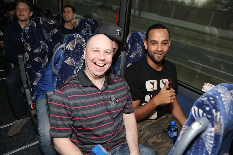 the man is on the bus next to the smiling man