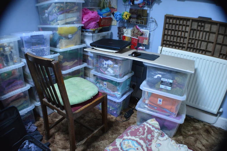 the room is cluttered and organized with plastic bins