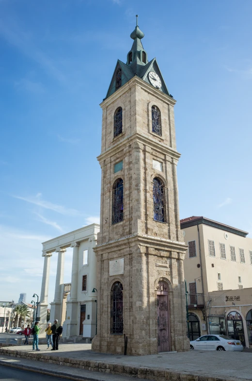 a large, tan brick tower has several clocks on it