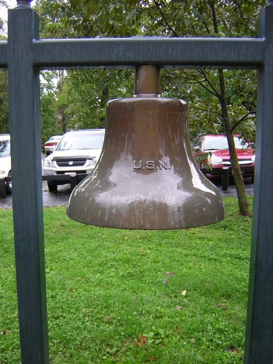 an old bronze bell on display in the grass
