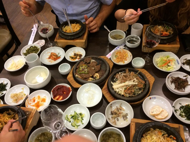 a dining table filled with food and people eating