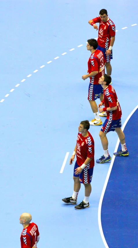 four male tennis players lined up on the court