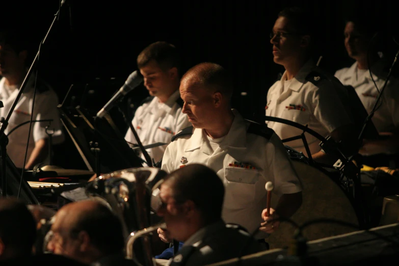 people in uniform, with microphones and several onlookers