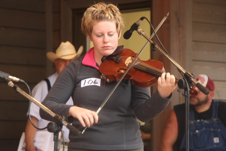 a woman holding a violin while standing next to a man