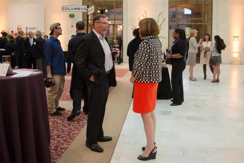 several people standing around in suits and ties talking