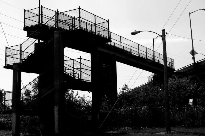 a tall wooden structure with metal stairs sitting next to a street sign