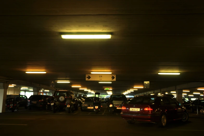 several vehicles are parked in an underground parking garage