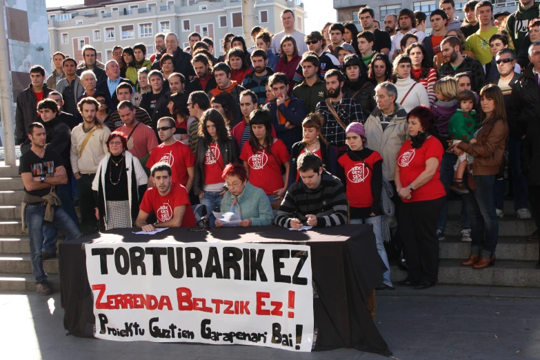 a crowd of people in front of stairs and some a sign