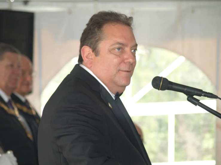 two men in military uniforms and one is giving a speech