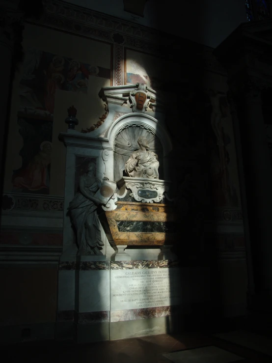 a statue in the corner of a room with paintings on the wall