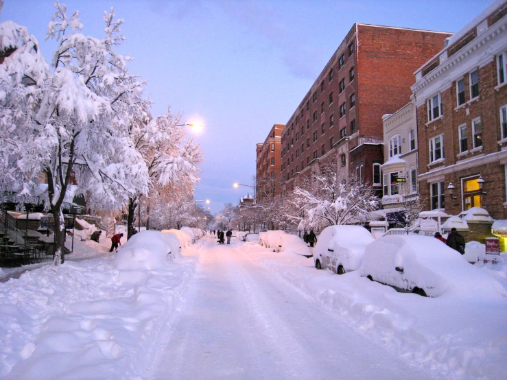 a snow covered street with many people walking on it