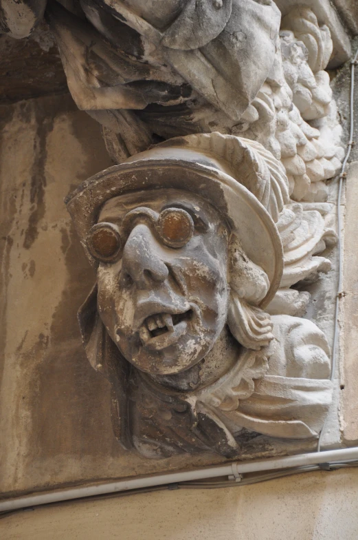 a stone sculpture of a man is wearing glasses and a hat