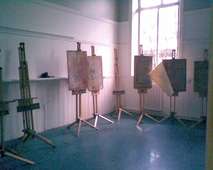 the room is empty with paintings on easels