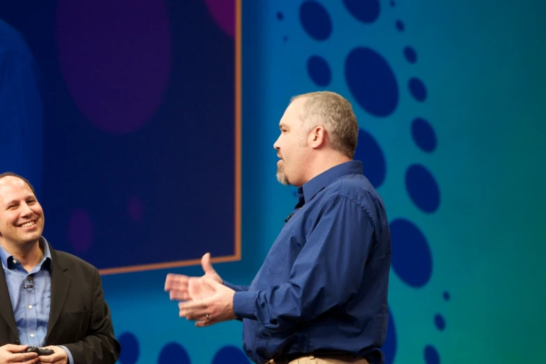 two men talking on stage during a conversation