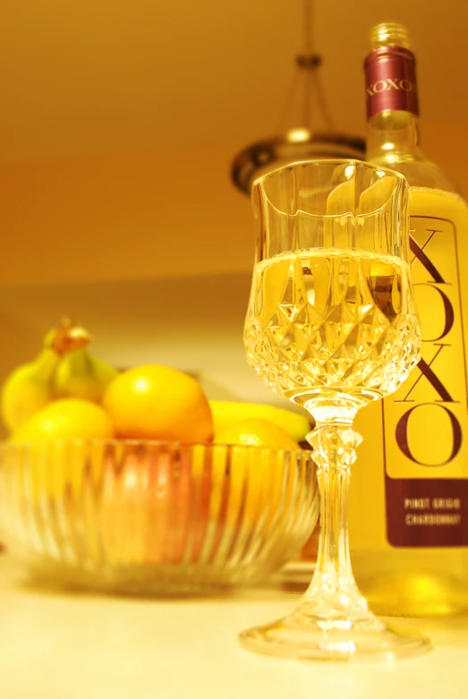 a white wine glass and a bottle on a table