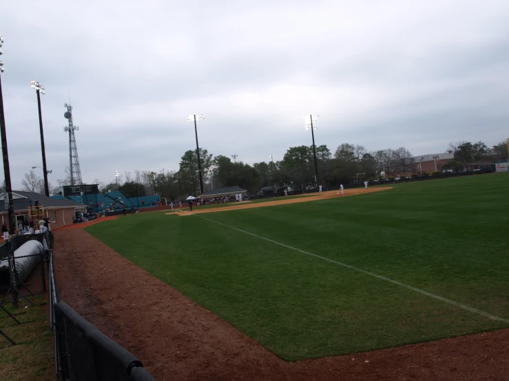 a baseball field with fans and a cloudy sky