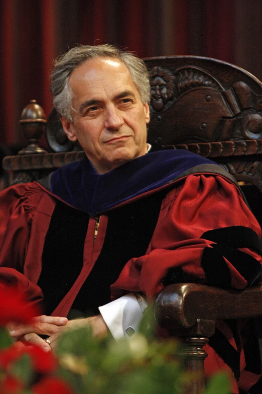 a man in a red robe sitting down