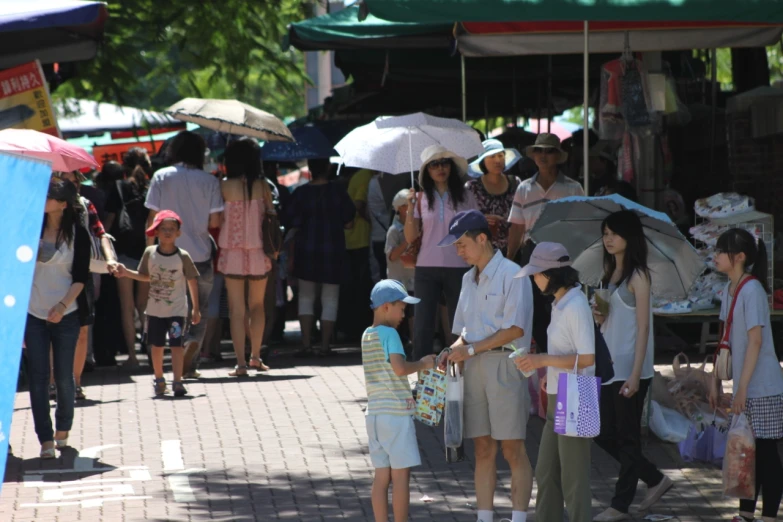 a crowd of people are walking around at a market