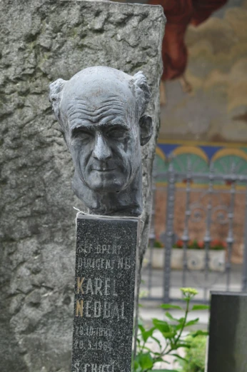a head of an old man on top of a stone monument