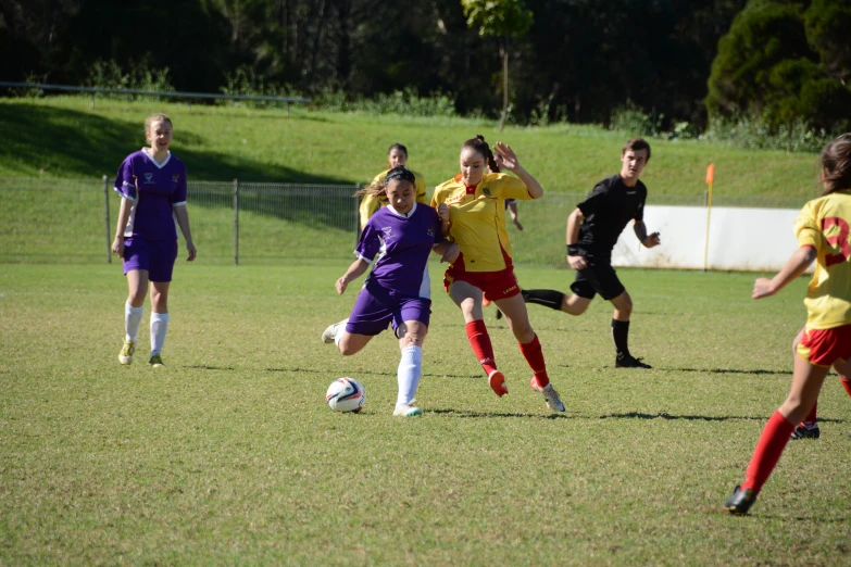 a group of girls playing soccer, in front of the goal