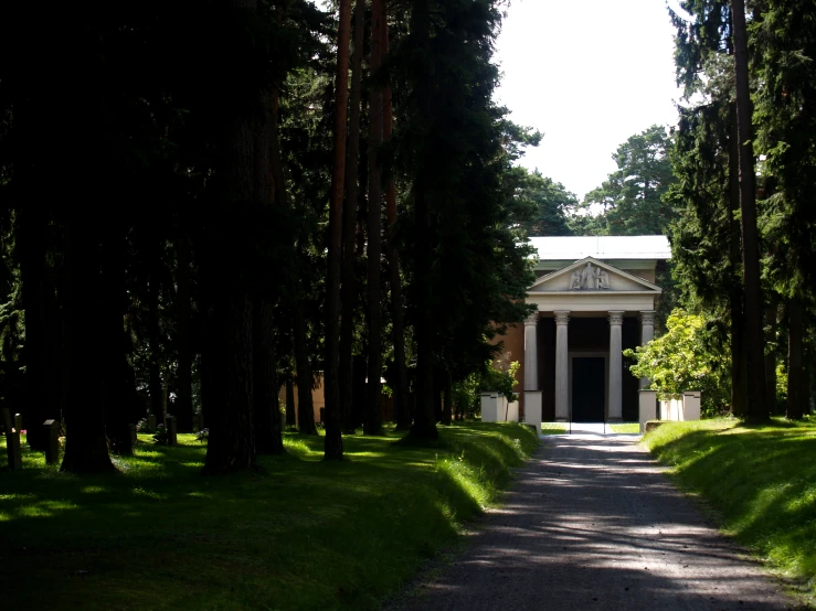 a large gazebo sitting among tall trees in the middle of a park