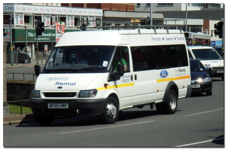 a transit van on the road surrounded by vehicles