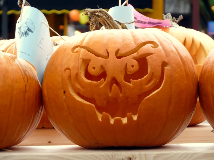 three pumpkins are carved to look like heads and faces