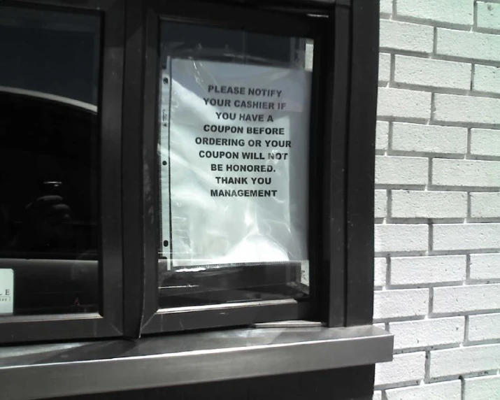 a white sign on a window with black frame