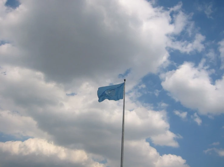 a flag flying in the wind under cloudy skies