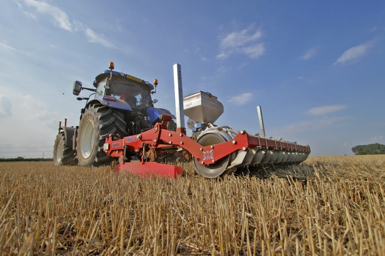 a tractor driving across a field in the middle of the day