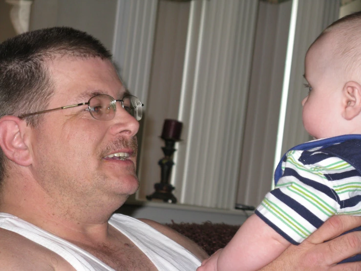 a man holding his baby while he looks at soing