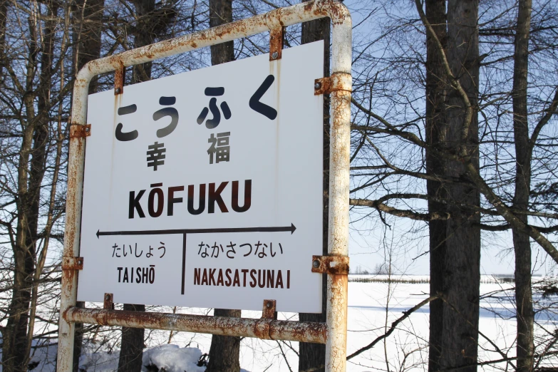 an information sign surrounded by snow covered trees