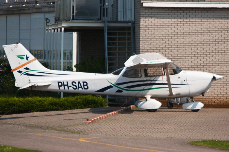 a small white plane parked near a building
