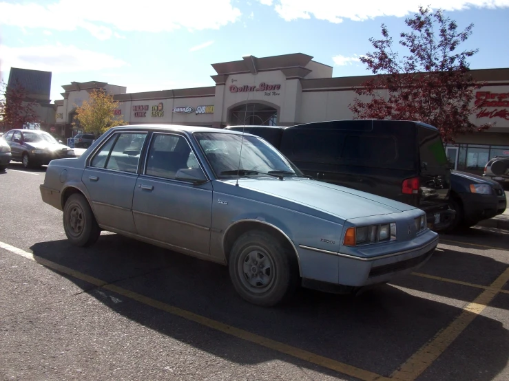 a grey car is parked in a parking lot near other vehicles