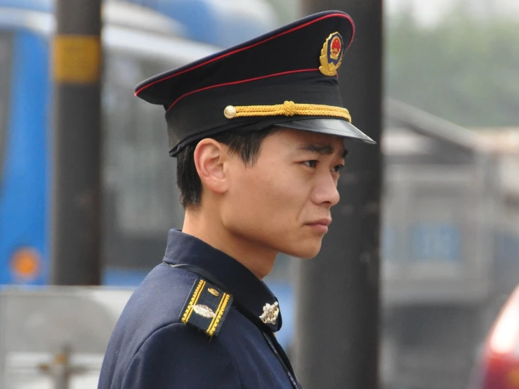 the man in the uniform of the commander is in front of a bus