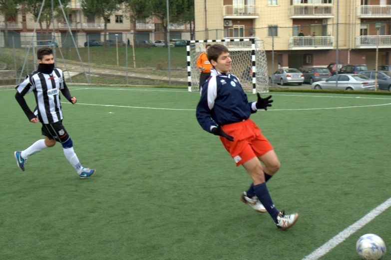 a pair of men play soccer against each other on a field