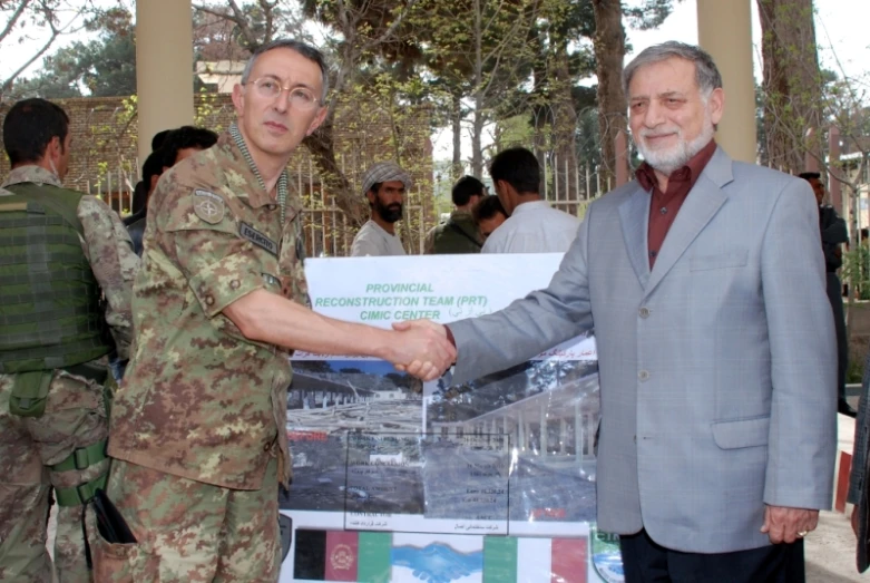 two men shaking hands in front of a poster