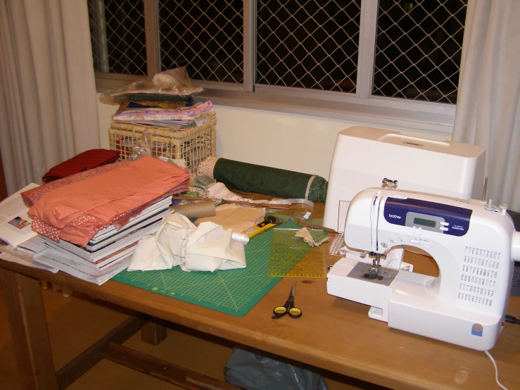 a sewing machine sitting on top of a table next to a pile of fabric