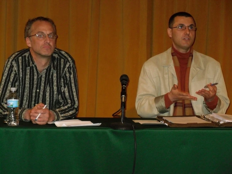 two men sitting down talking to each other