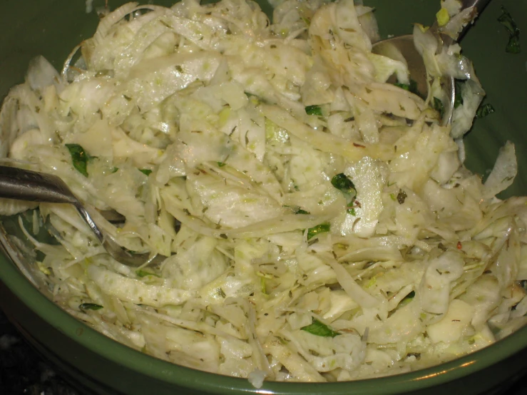 a bowl of food with some silver ware on it