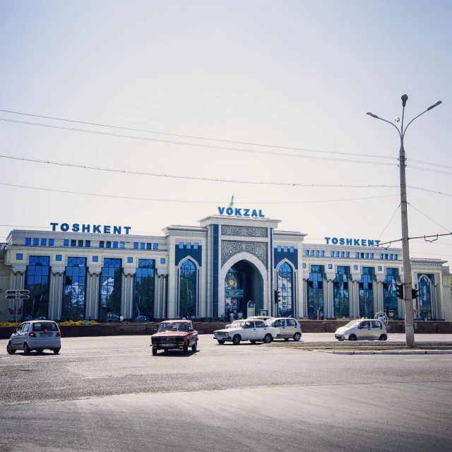 a building with a big blue door is next to several cars