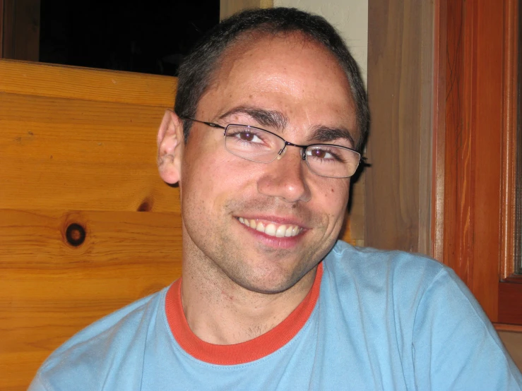 man smiling for camera at home by a window