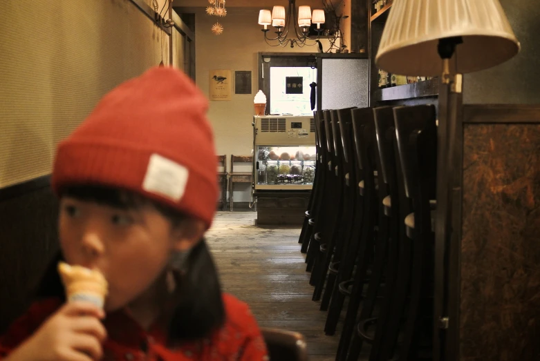 a  in a red hat eating ice cream