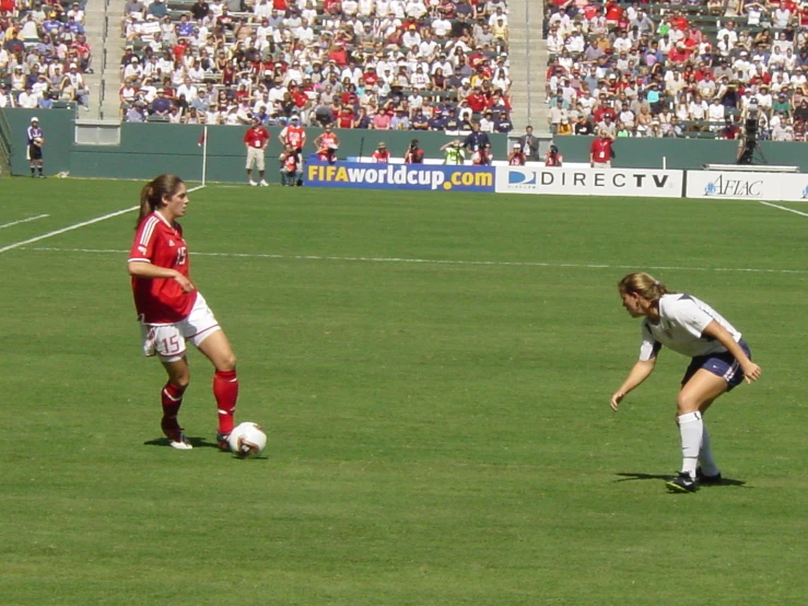 two women are playing a game of soccer