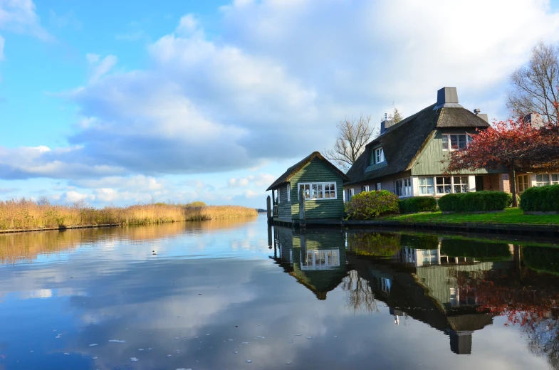 an old house sits along the side of a river