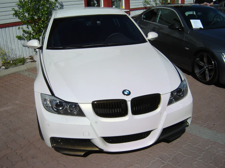 white car parked next to other cars in a lot