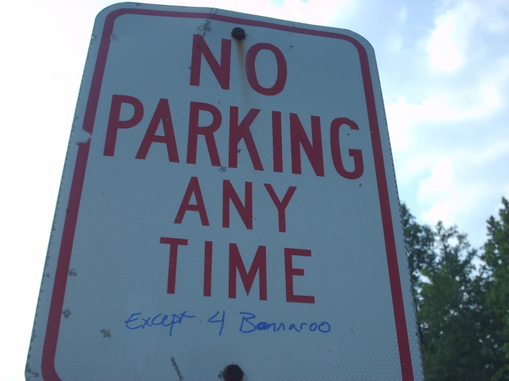 a sign has the words no parking any time painted on it