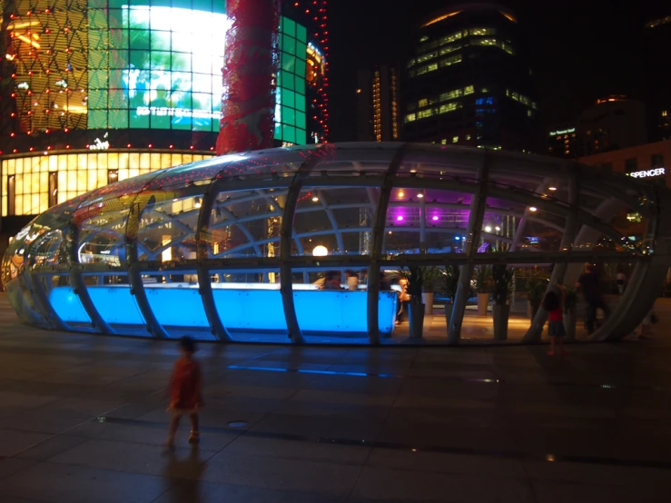 a building with glass dome on top is in the middle of a large city