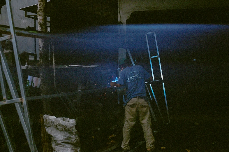 a man is looking at soing while standing on a ladder