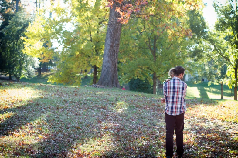 a man is standing in the grass near trees